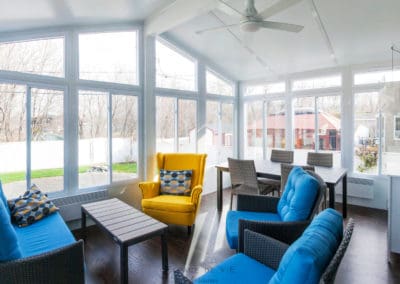 mobilier coloré dans un solarium blanc vitré