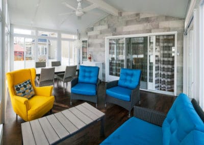 mobilier coloré dans un solarium blanc vitré